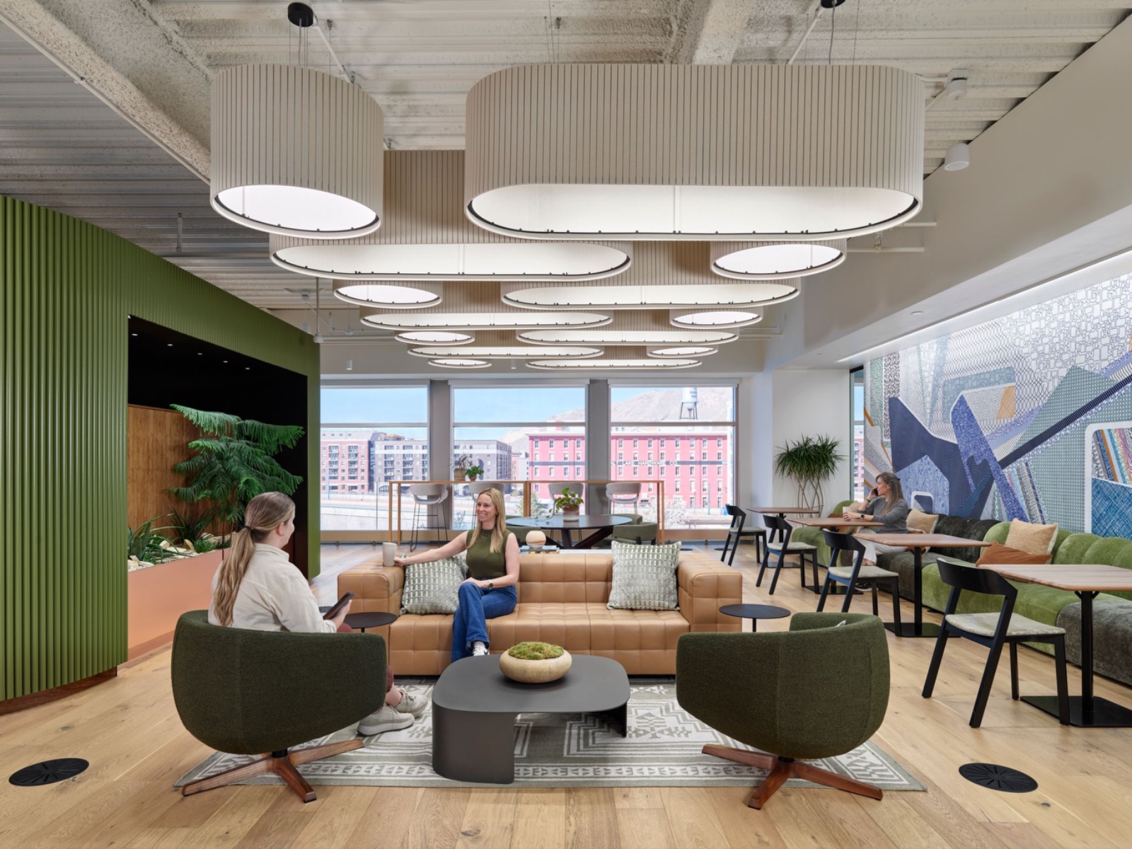 Workplace lounge with sculptural lighting and a mountain view, the finished space an earlier scenario study was built to protect